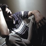 Man sitting in darkness all alone and depressed.