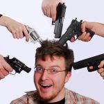 image of a man with multiple guns pointed at his head
