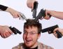 image of a man with multiple guns pointed at his head
